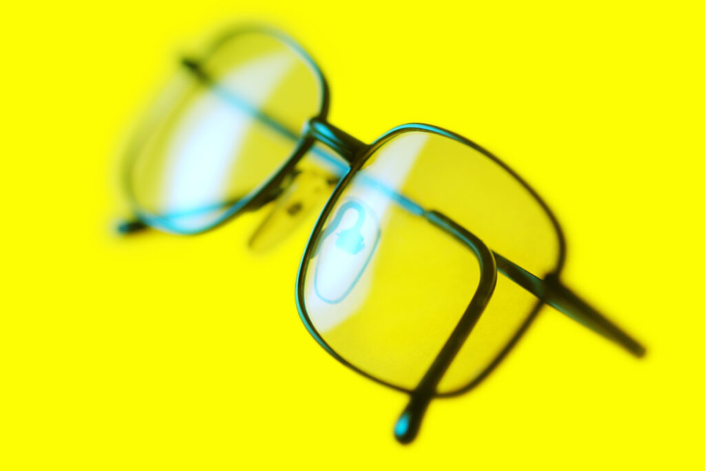 Close-up of a pair of spectacles or eyeglasses designed to improve vision, with silver frames and clear lenses.