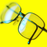 Close-up of a pair of spectacles or eyeglasses designed to improve vision, with silver frames and clear lenses.