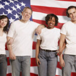 American flags, with a diversity of citizens standing in front. Men in jeans and t-shirts.