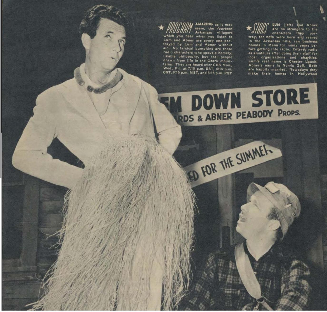 Two men dressed in traditional Hawaiian attire, Lum and Abner, are seen mid-dance in the center of a small store. Lum, on the left, is playing a ukulele while Abner on the right is swaying his hips and waving his arms. A small crowd is gathered around them, some clapping and others smiling. The store itself is cluttered with various items, including shelves of canned goods and hanging clothes, giving it a cozy and lived-in feel.